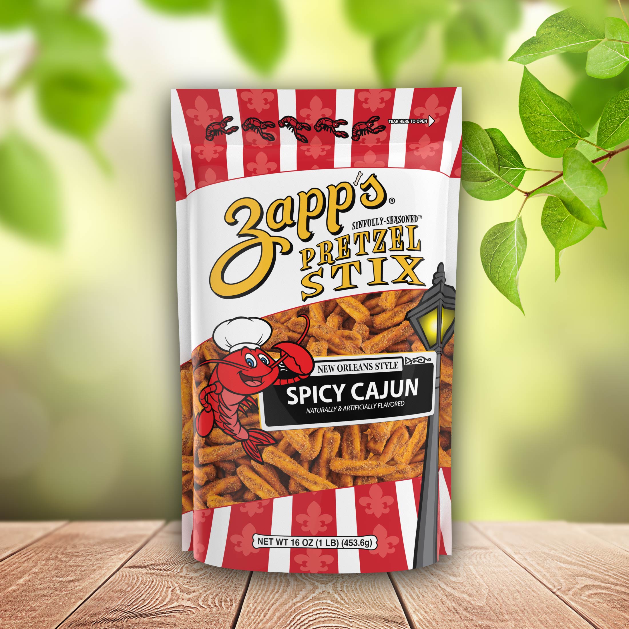 Zapp's Spicy Cajun Pretzel Stix packaging on a wooden surface with green leaves in the background