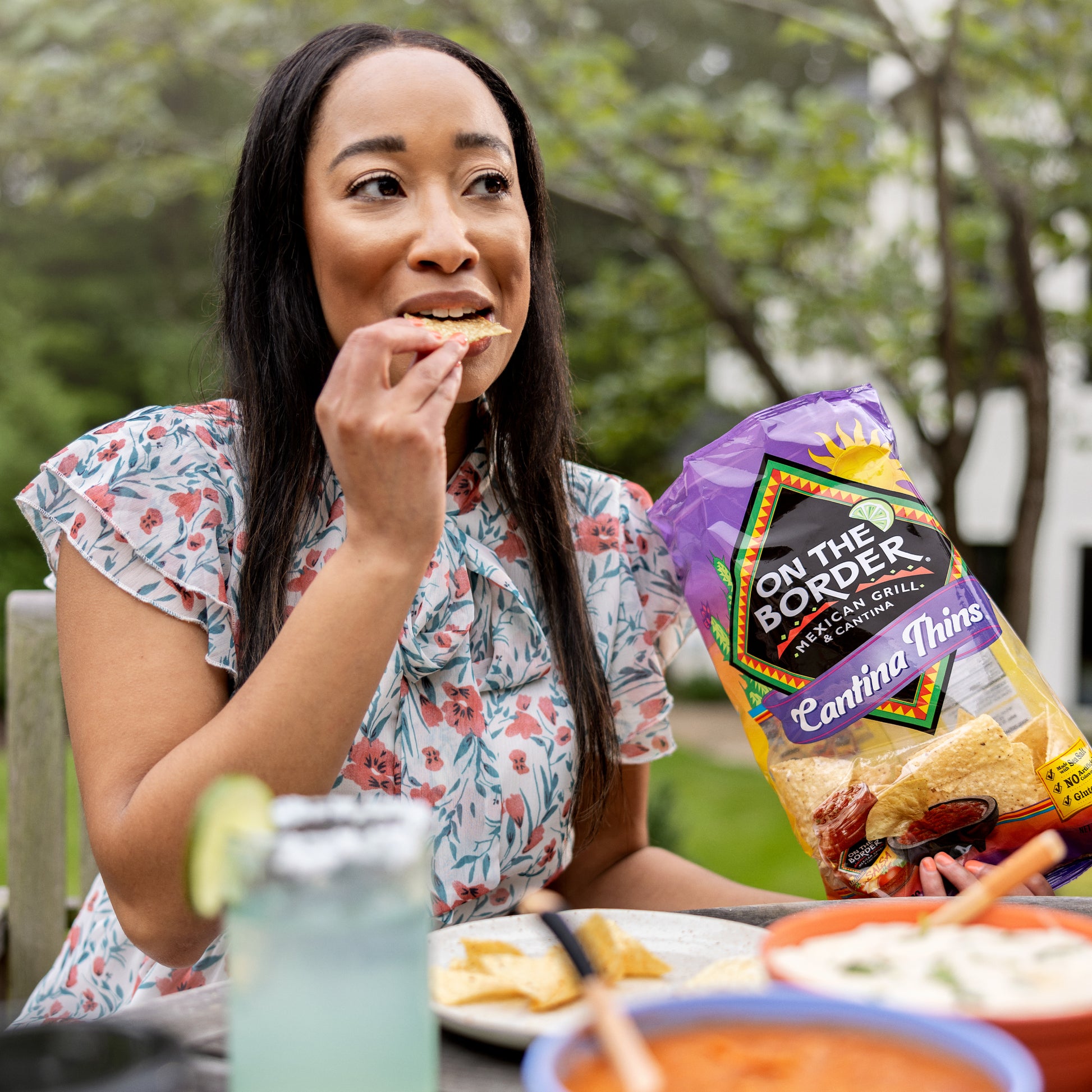 Person enjoying On The Border Cantina Thins tortilla chips outdoors