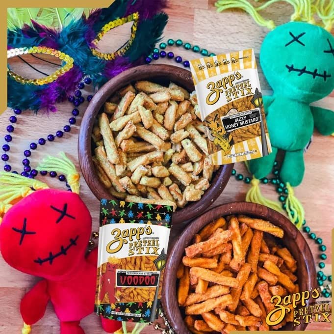 Snack mix with Zapp's Pretzel Stix and Zapp's Jalapeno Mustard on a table with colorful decorations.