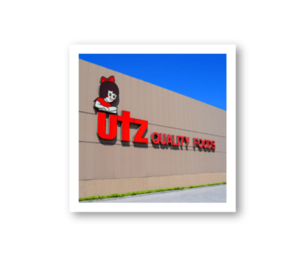 UTZ Quality Foods logo on a building facade with blue sky.