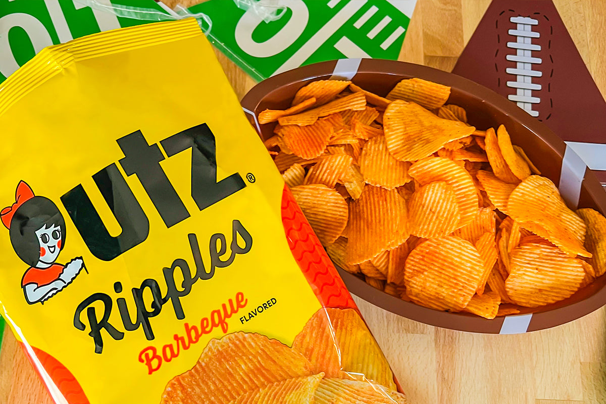 UTZ Ripples Barbeque flavored chips in a bowl with packaging on a wooden surface