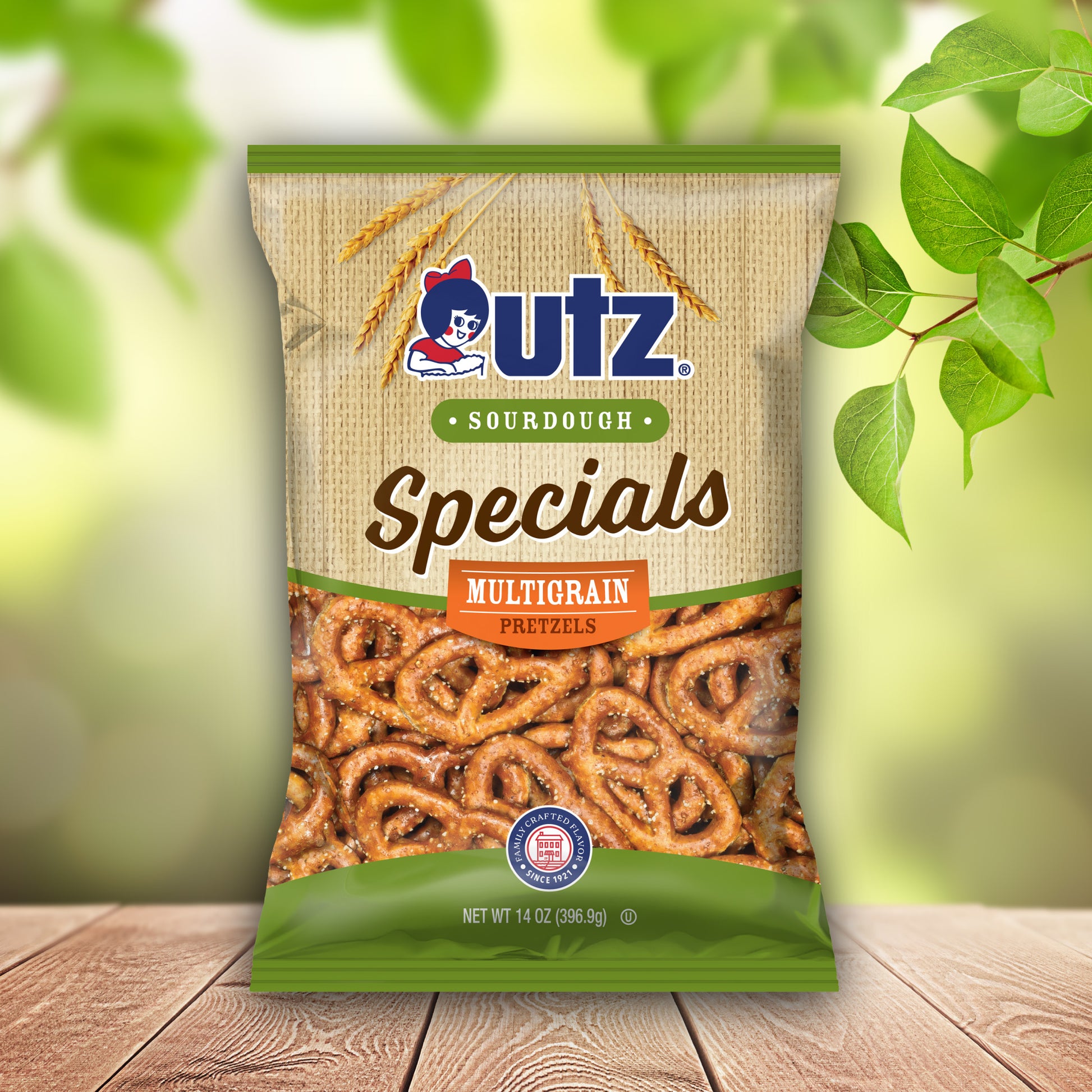 UTZ Sourdough Specials Multigrain Pretzels packaging on a wooden surface with green leaves in the background