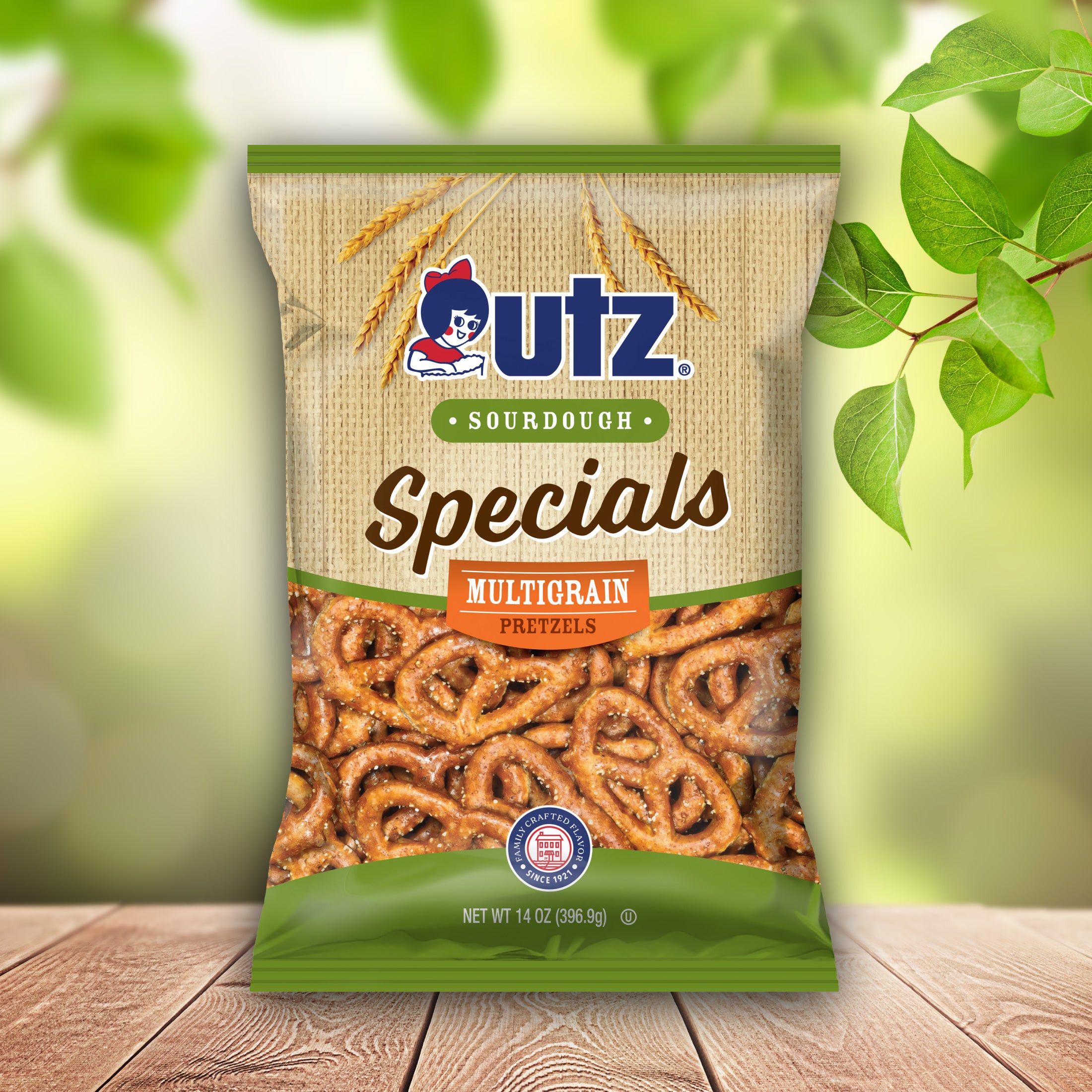 UTZ Sourdough Specials Multigrain Pretzels packaging on a wooden surface with green leaves in the background