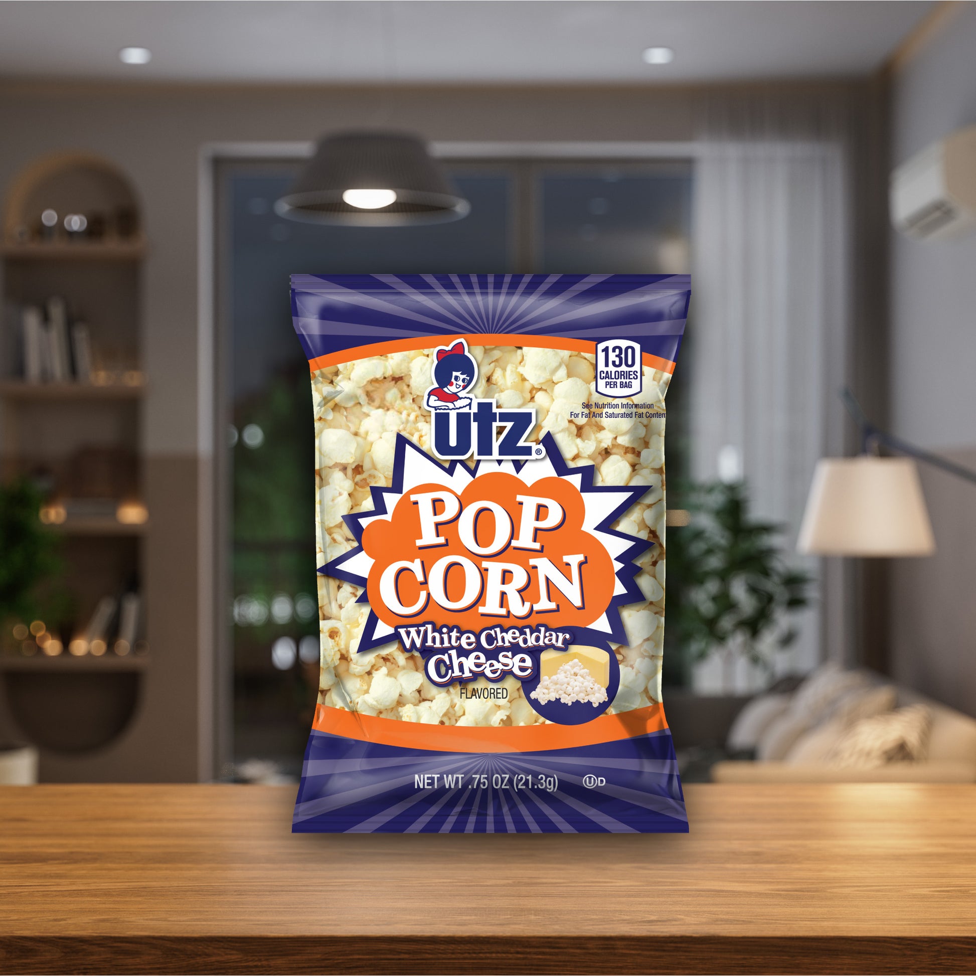 UTZ Pop Corn White Cheddar Cheese packet on a wooden table with a blurred indoor background