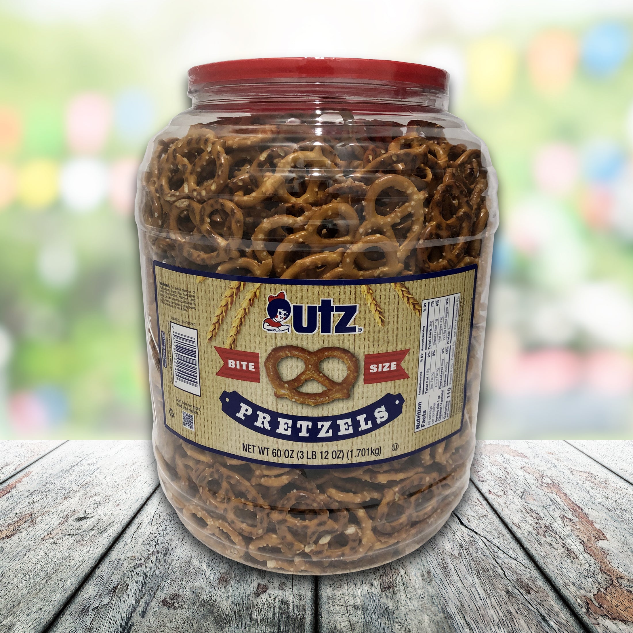 Jar of Utz pretzels on a wooden surface with a blurred colorful background