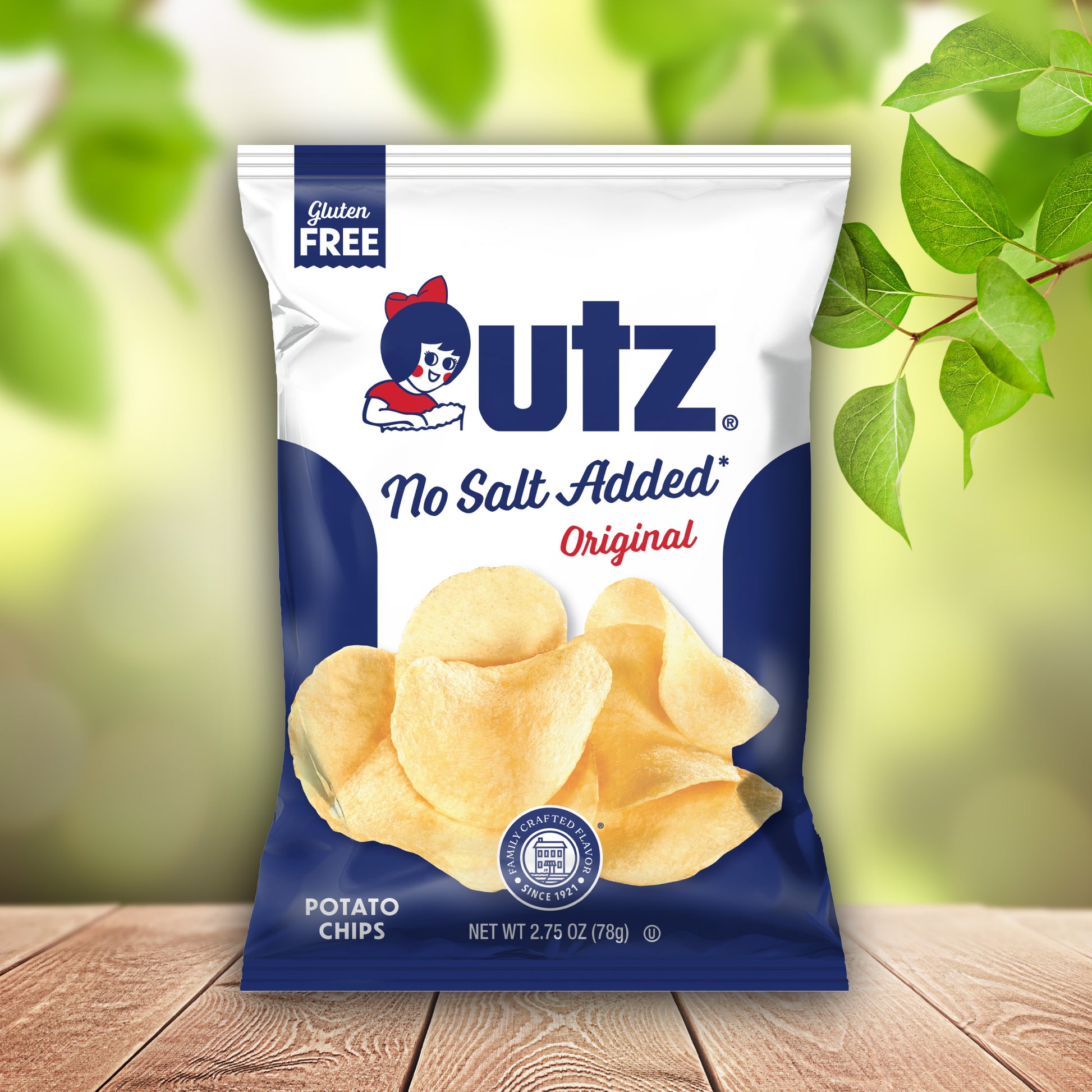 UTZ no salt added potato chips packaging on a wooden surface with green leaves in the background
