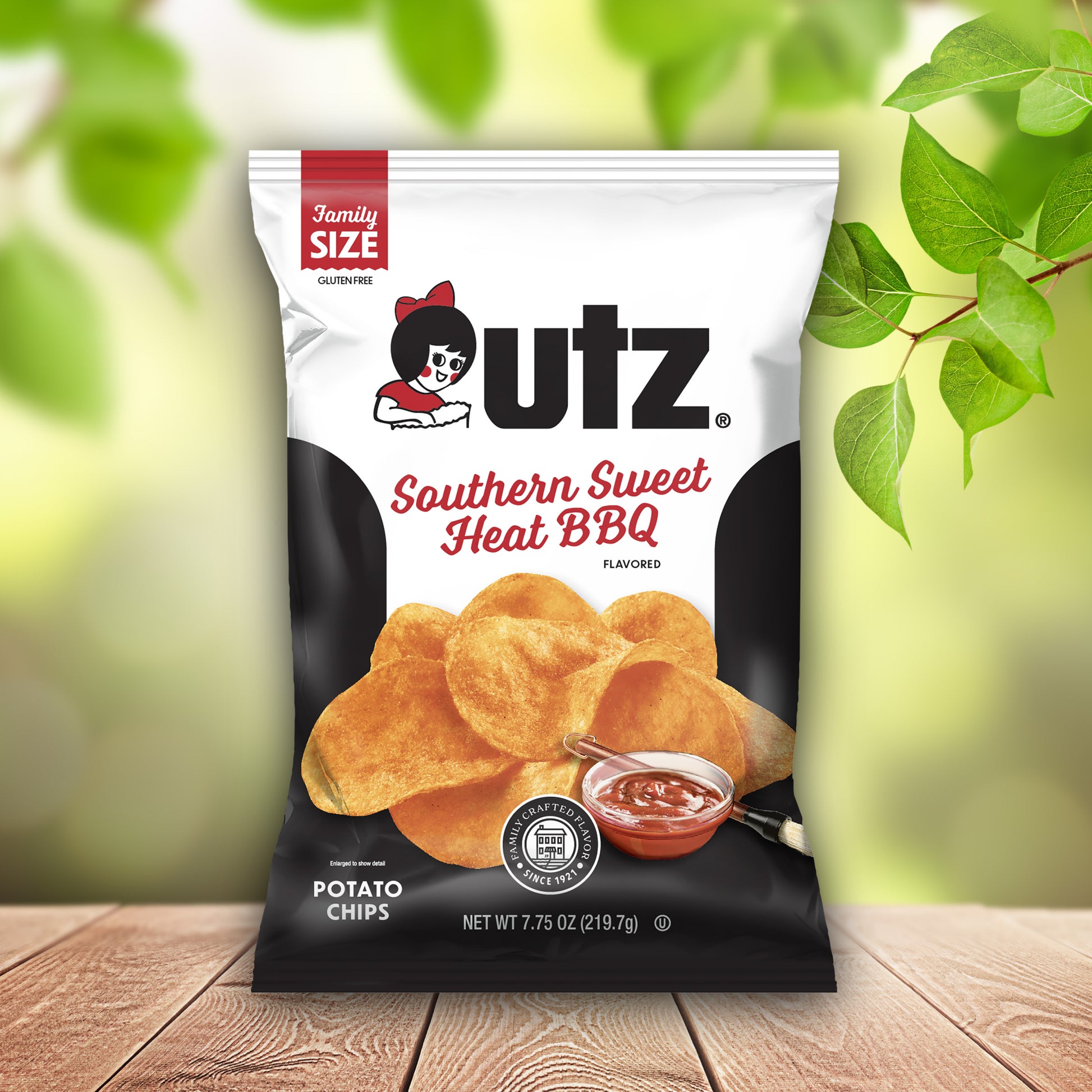 UTZ Southern Sweet Heat BBQ potato chips bag on a wooden surface with green leaves in the background