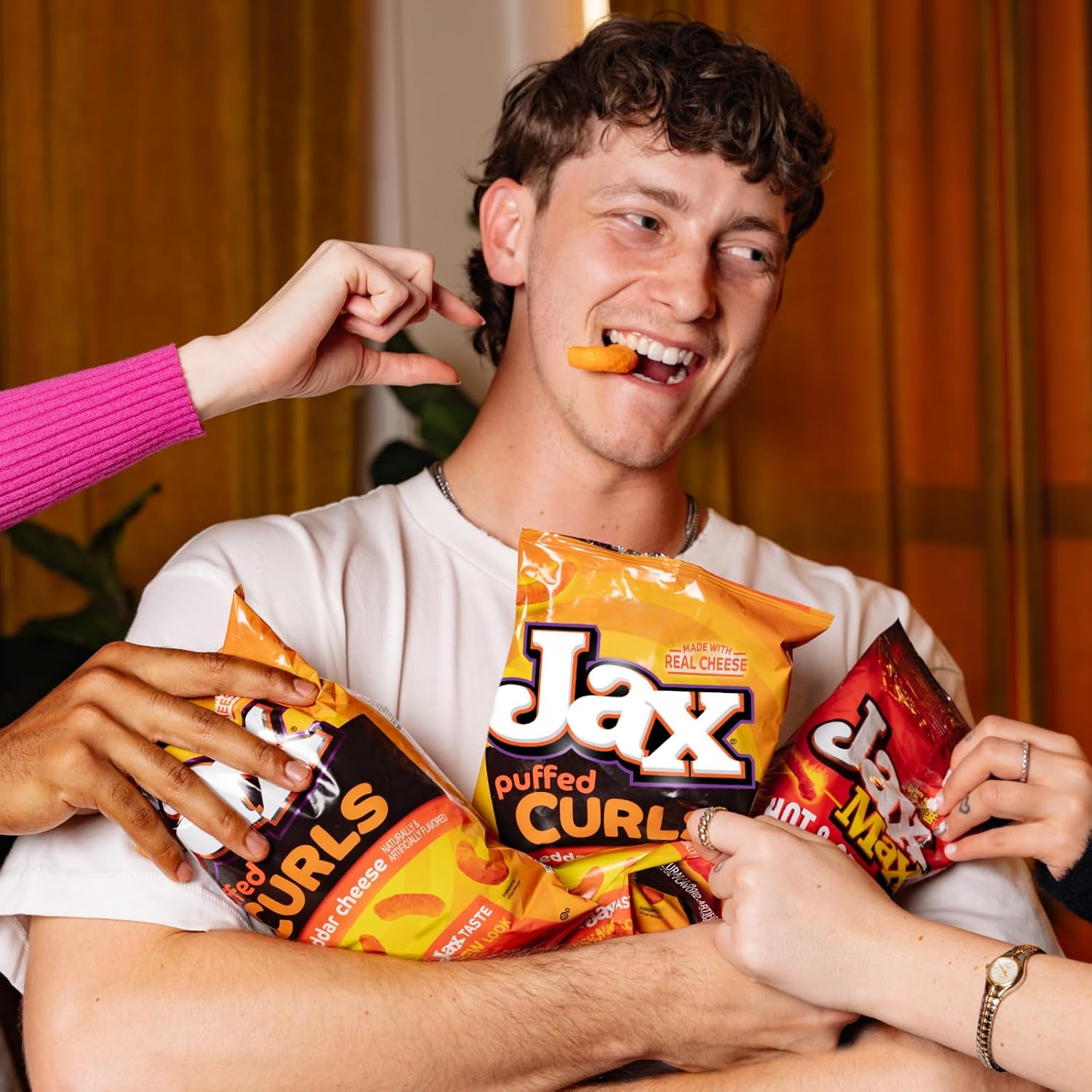 Person holding Jax puffed curl snacks with a casual setting