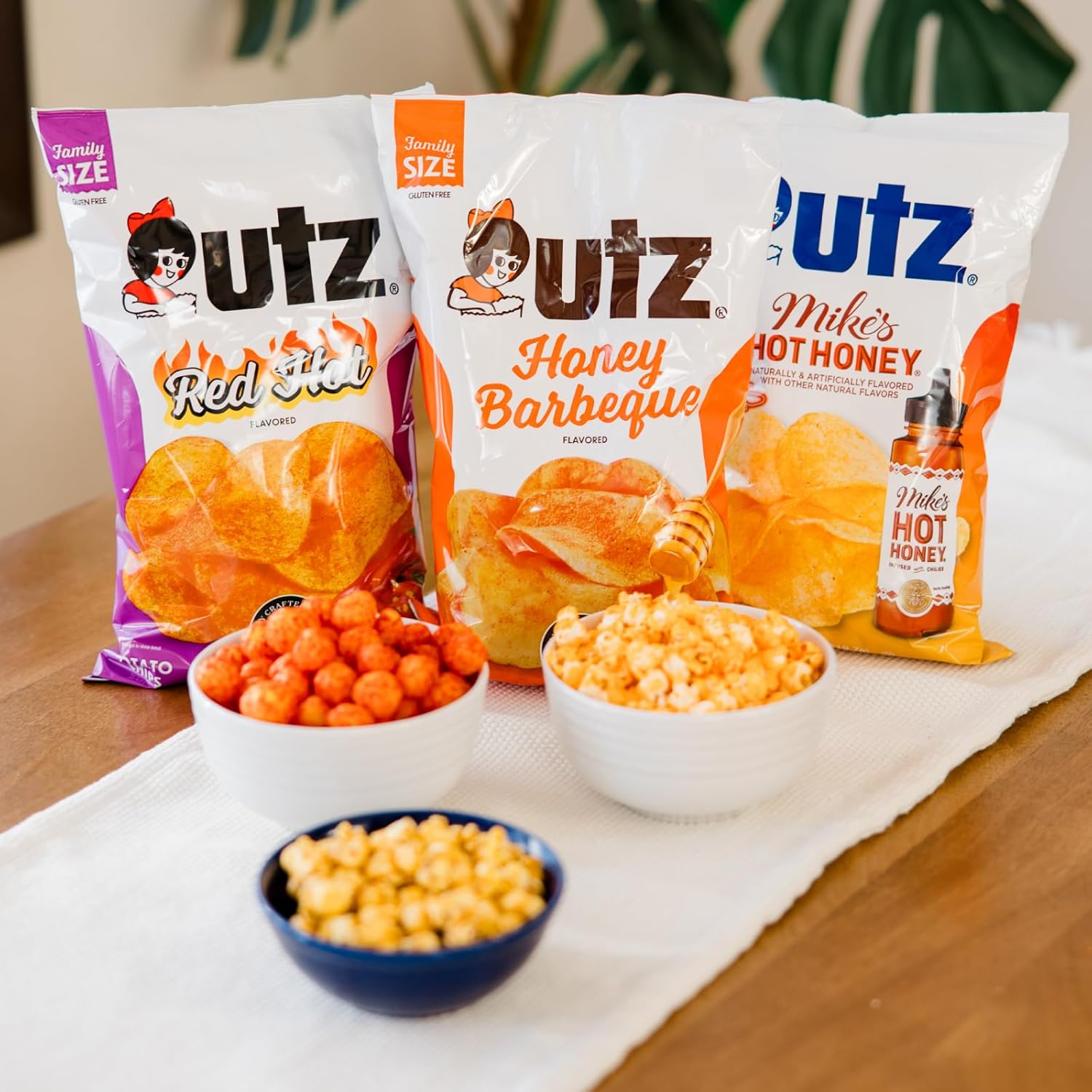 Three Utz snack bags with corresponding snacks on a table.