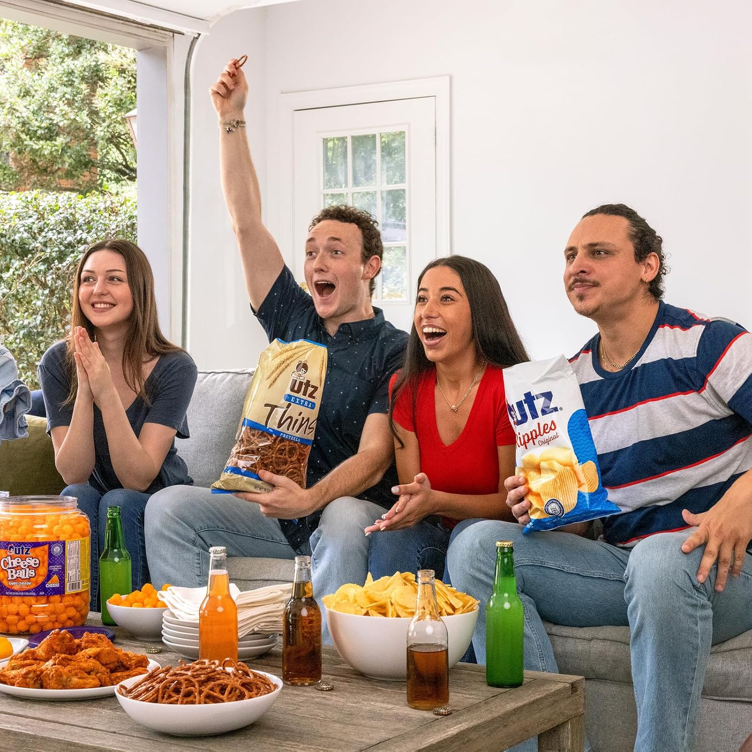 Group of friends enjoying snacks and drinks together in a living room.