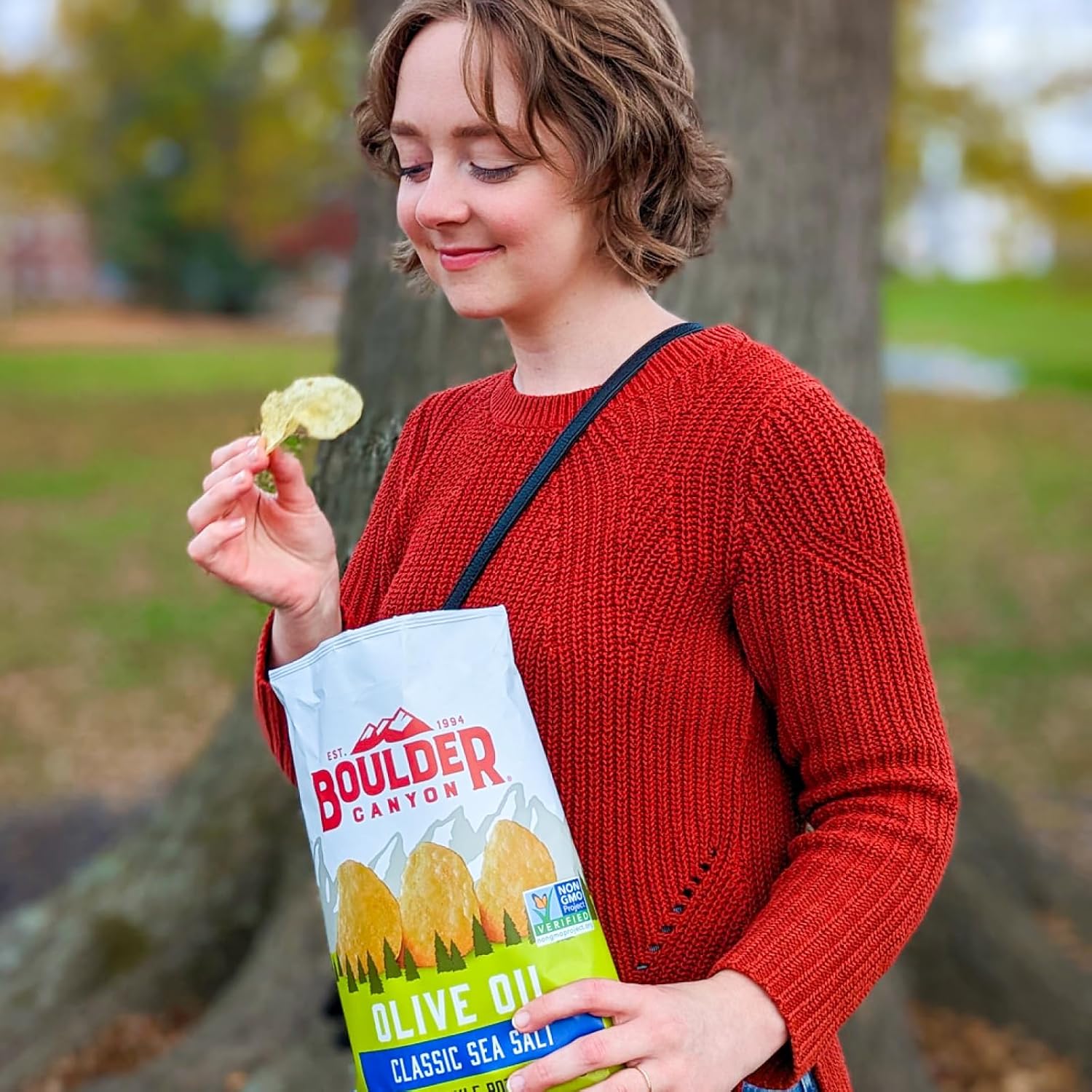 Woman holding a Boulder Canyon olive oil bag outdoors