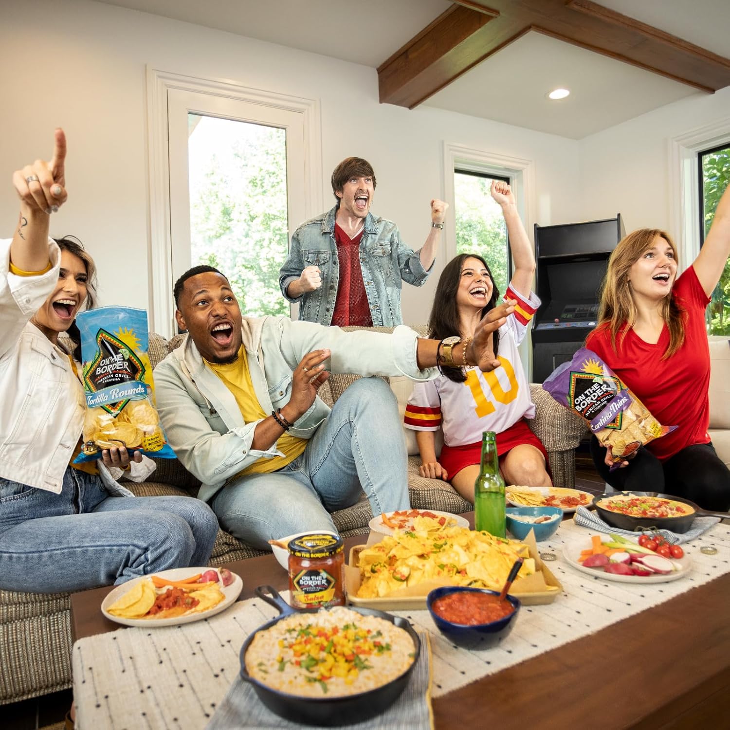 Group of friends enjoying a casual gathering with snacks and drinks in a living room.