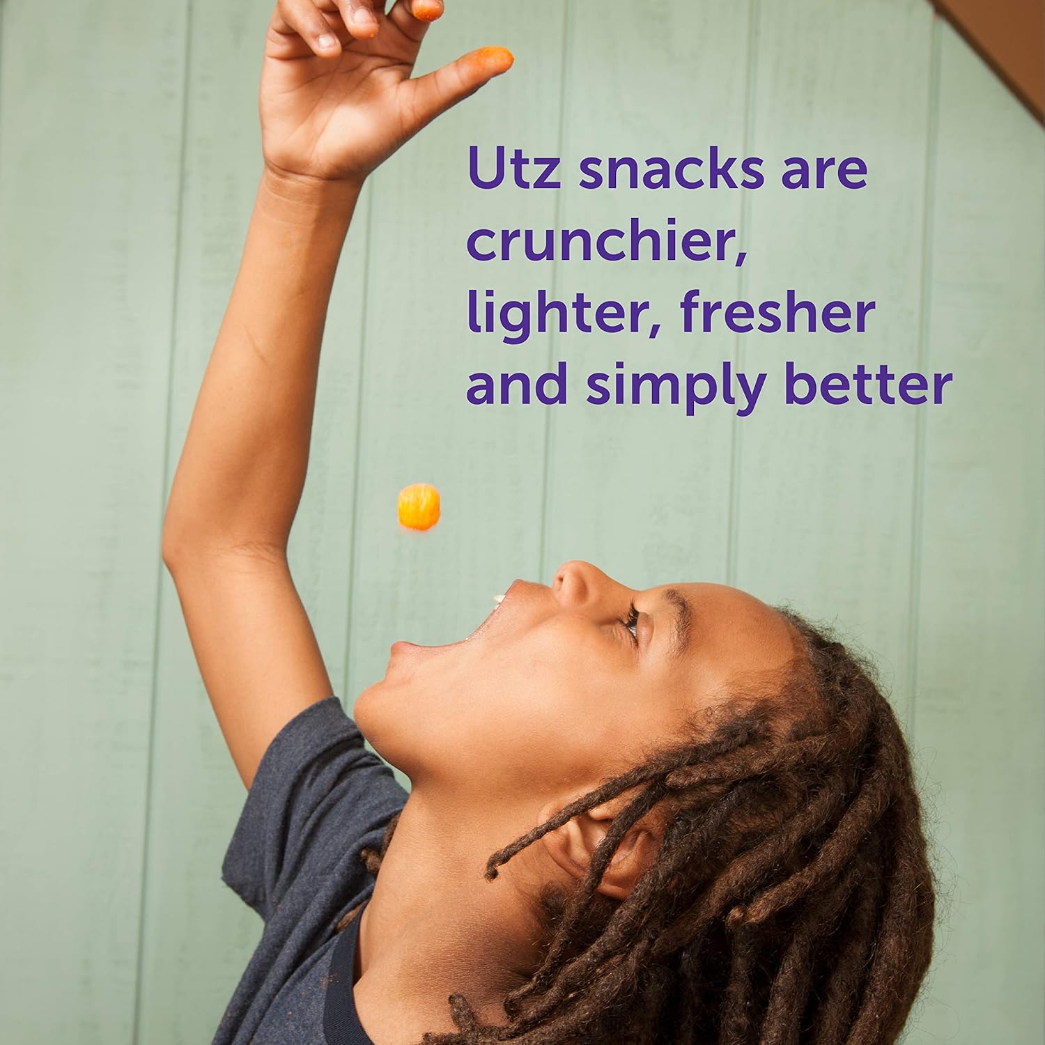 Child reaching up to catch a snack with Utz snack advertisement text.