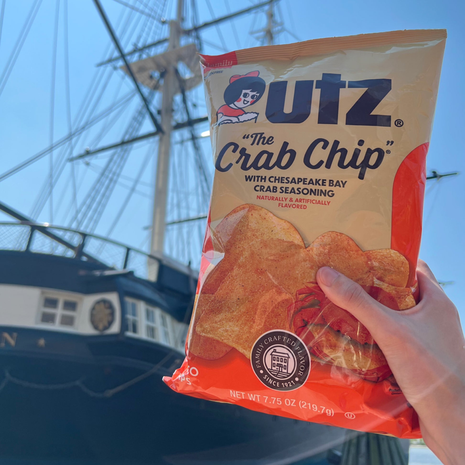 Outz Crab Chip bag held in front of a ship