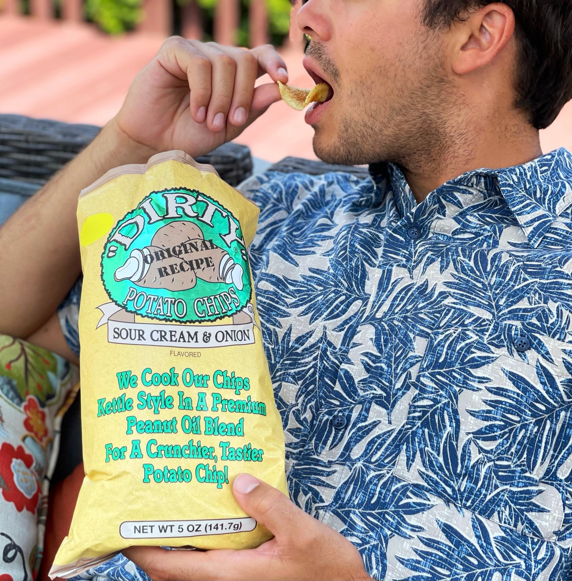 Person eating Dirty Potato Chips with a bag in hand