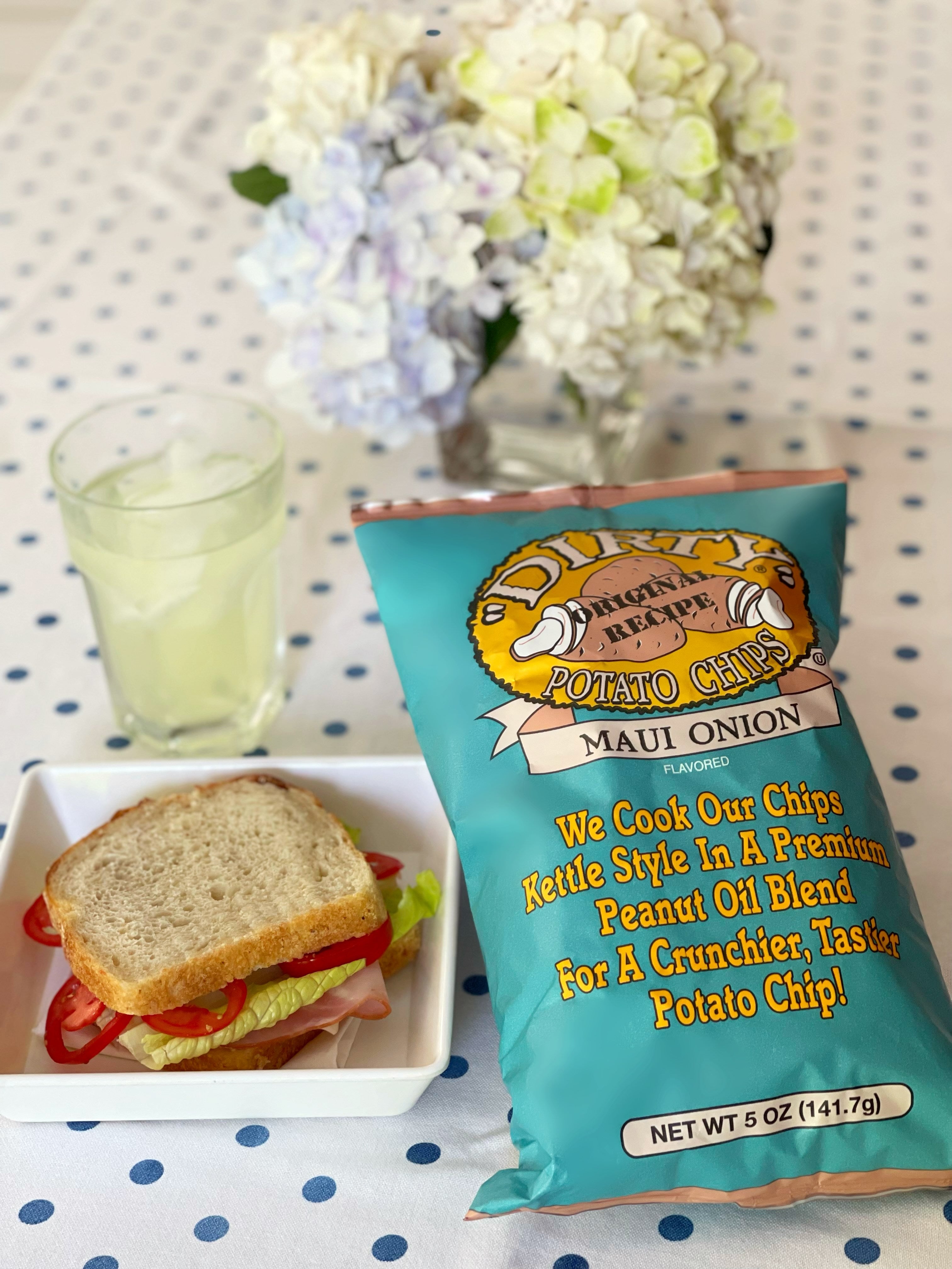 Maui Onion potato chips packet with a sandwich and drink on a polka dot tablecloth
