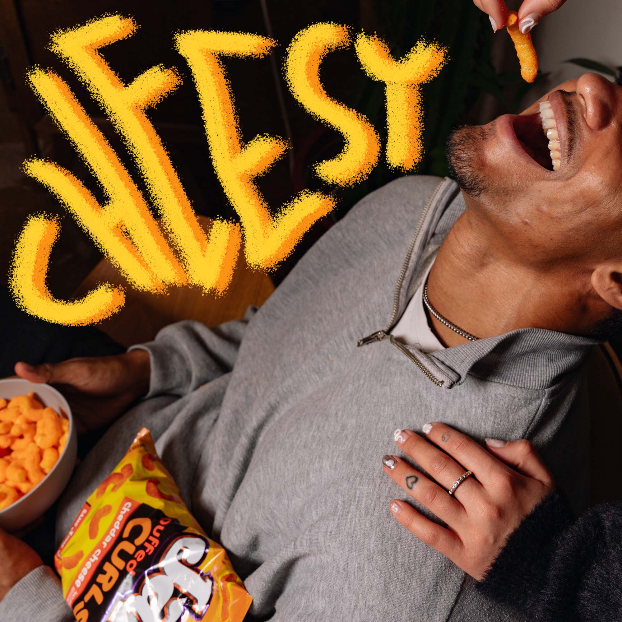 Person eating cheesy snacks with a bag of Fritos in the foreground