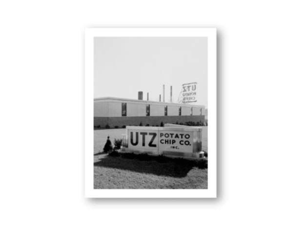 Vintage black and white photo of a UTZ Potato Chip Co. truck in front of a building.
