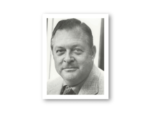 Black and white portrait of a man with a neutral expression on a white background