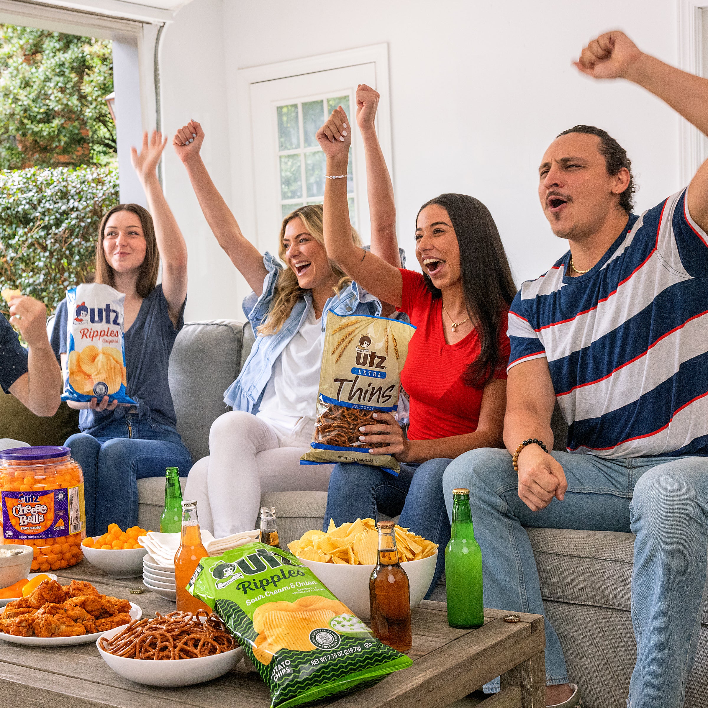Group of people celebrating with snacks and drinks on a couch