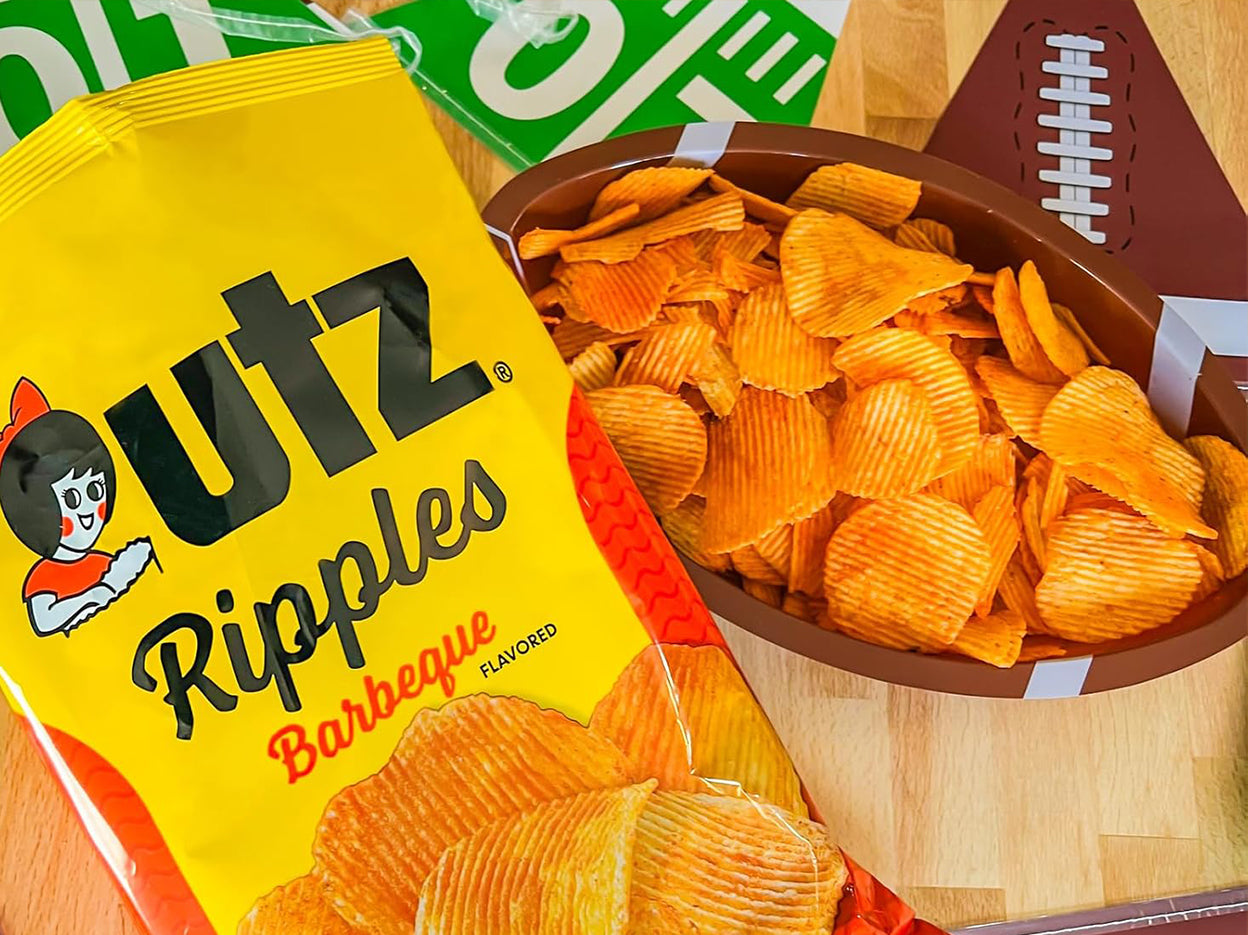 Outz Ripples Barbeque flavored chips in a bowl with packaging on a wooden surface